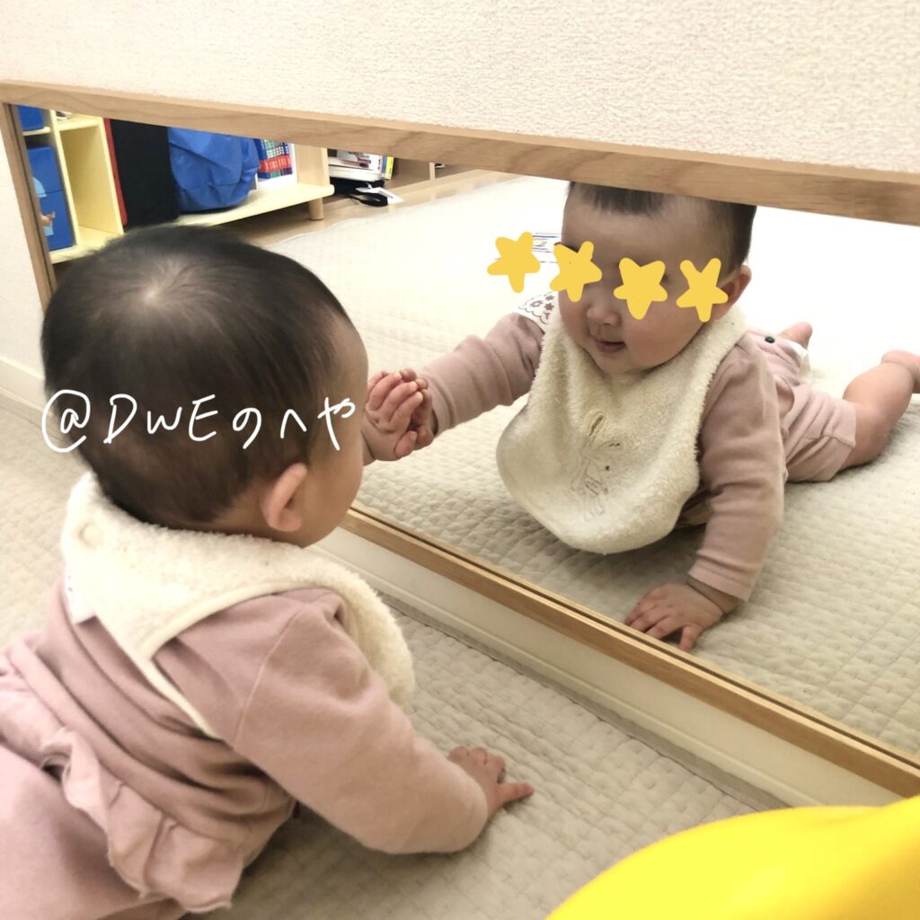 無印の壁掛け鏡を見る赤ちゃん